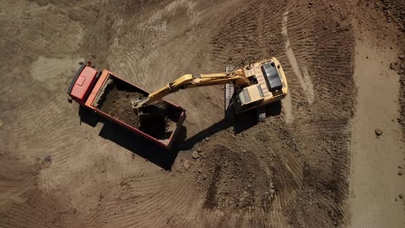 Aerial View of Excavator Pours Sand Into the Truck