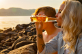 Young Woman Drinking Beer By Boyfriend At Beach - PhotoDune Item for Sale