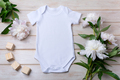 White baby short sleeve bodysuit mockup with peony and toy blocks - PhotoDune Item for Sale