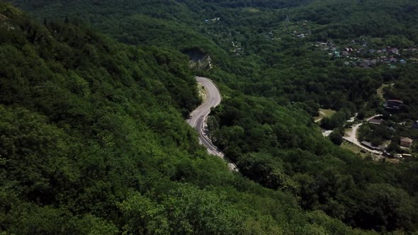 Aerial View From Above of Curve Road with a Car on the Mountain with Green Forest in Russia