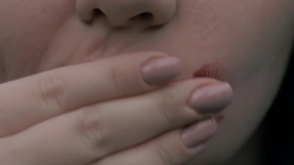 Closeup of Young Woman Mouth Woman Smears Red Lipstick on Her Face
