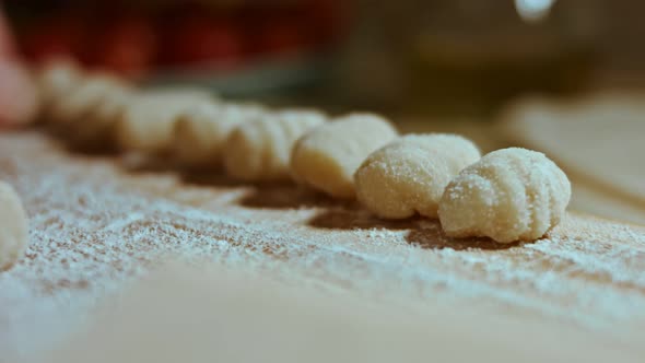 Chef Cutting Rolls of Potato Dough for the Preparation of Homemade Gnocchi Pleasant Atmosphere