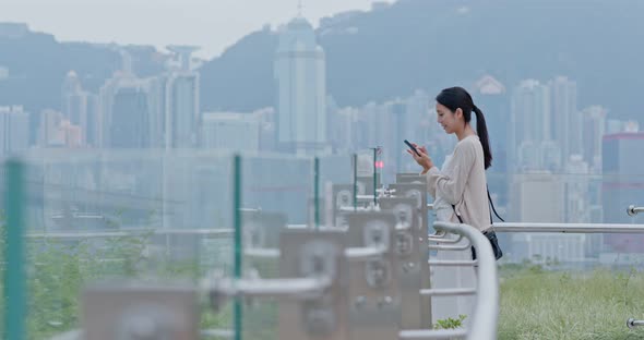 Woman look at smart phone in city