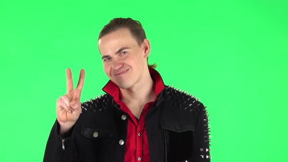 Guy Shows Two Fingers Victory Gesture. Green Screen