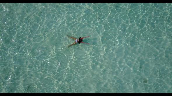 Lady suntans on relaxing resort beach voyage by blue lagoon with white sand background of the Maldiv