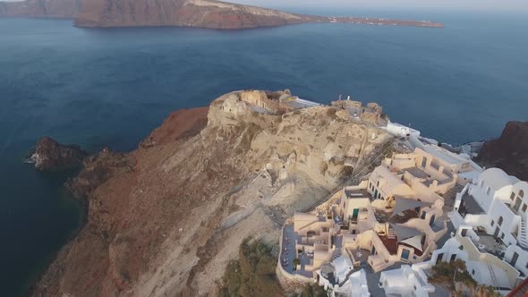 Aerial footage of Oia castle on Santorini Island in Greece during sunrise
