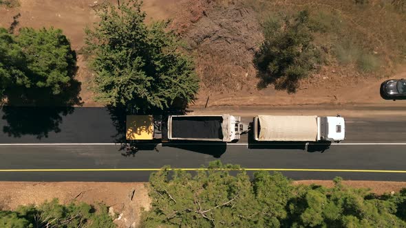 Asphalt paving machine escorted by an Asphalt truck at work, Top down aerial view.