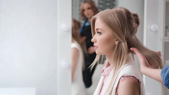 Professional Hairdresser Creating Volumizing on Hair of Model Using Comb