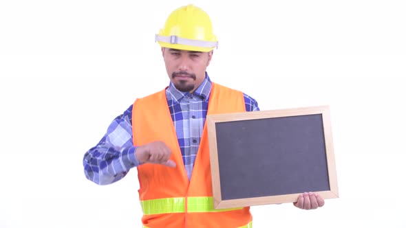 Stressed Bearded Persian Man Construction Worker Holding Blackboard and Giving Thumbs Down