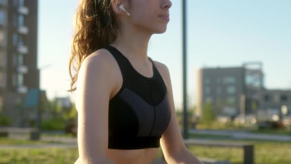Close Up Attractive Athletic Girl in Black Tight Clothes Does Sports Squats on Sports Ground in Her