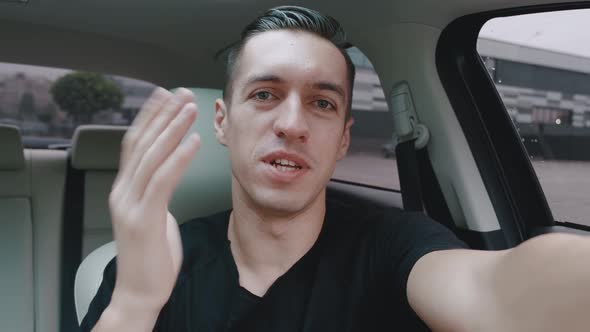 Smiling Young Man Driver Making Selfie or Video Call While Sitting in a Car. Portrait of Male