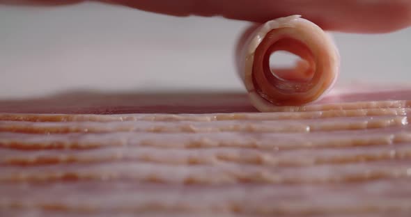 Macro Shot of the Slice of Bacon is Rolled Up By Finger