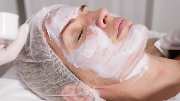 Doctor Applies an Anesthetic Cream on the Face of His Patient Lying