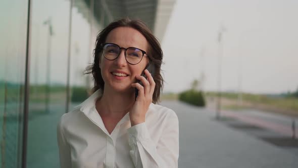 Portrait of a Happy, Smiling Girl Talking on the Phone. Business Theme. Slow Motion