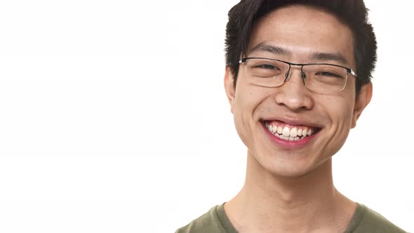 Portrait Closeup of Content Chinese Man 20s Wearing Eyeglasses Smiling with Perfect Teeth Near Copy