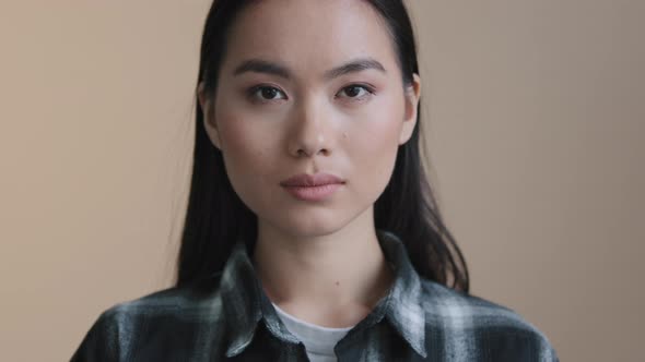 Close Up Headshot Female Face with Perfect Skin Makeup Asian Serious Calm Model Woman Satisfied