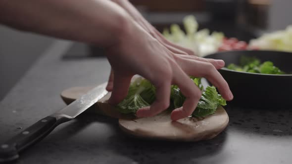 Slow Motion Man Hand Take Chopped Romaine Lettuce From Wood Board To Make Salad