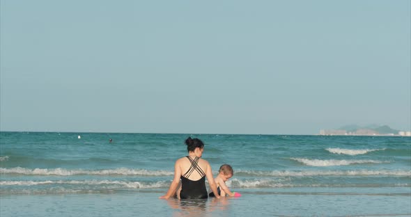 Happy and Carefree Mother and Son Play By the Sea, Sunbathe, Swim. Children and Adults Play