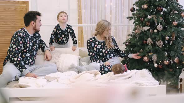 Happy Parents and Children Have Fun Near Christmas Tree at Home