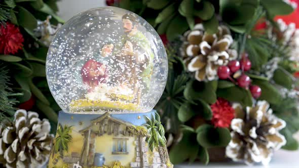 Snowglobe with child in the manger on Christmas background. Flat plane