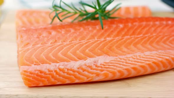 Fresh raw salmon fillet on wooden board, dolly shot