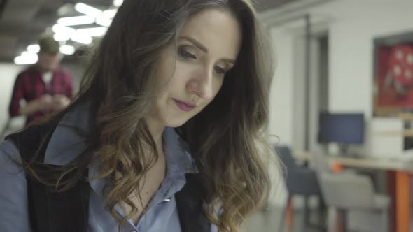 Porter of a Successful Business Girl with Dark Documentary Sitting Hair in an Office