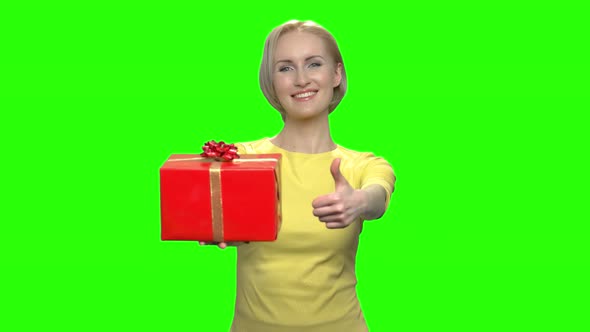 Happy Middle Aged Woman with Red Gift Box and Thumb Up