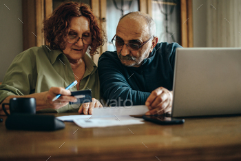 le going through some paperwork and calculating their monthly budget at home