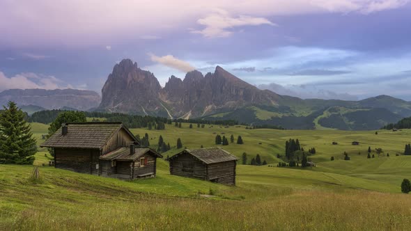 Timelapse video of the Sassolungo mountains on the Italian Alps Dolomites with wood houses on the fo