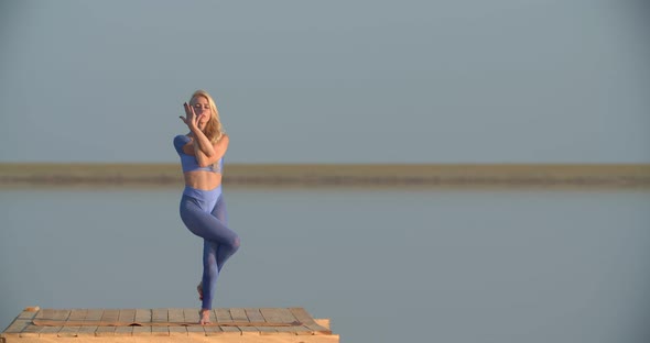Blonde Lady Wearing Sports Clothes is Doing Yoga Poses During Sunset Outdoor