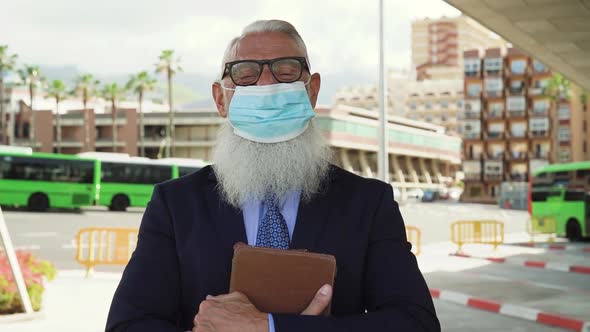 Senior business man posing in front of camera while wearing face mask during corona virus outbreak