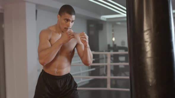 Kickboxing Athletic Man Fighter Trains His Punches Training Day in the Boxing Gym