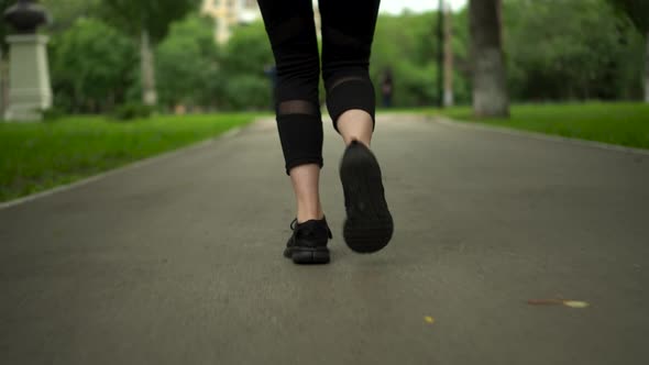A Young Woman is Jogging in the Park