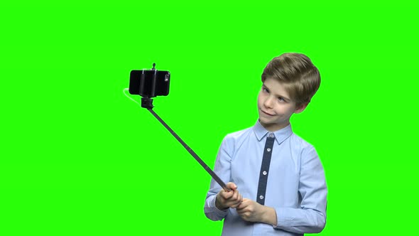 Little Boy Fooling Around and Making Photos Using Selfie Stick