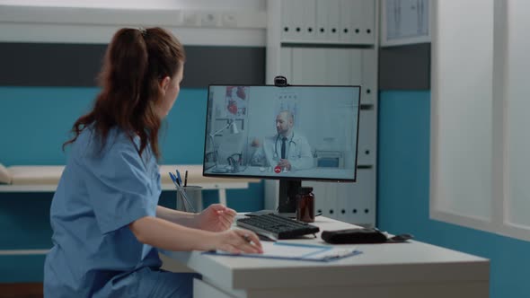 Medical Assistant Talking to Doctor on Video Call Conference