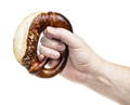 male hand holds bretzel with salt isolated - PhotoDune Item for Sale