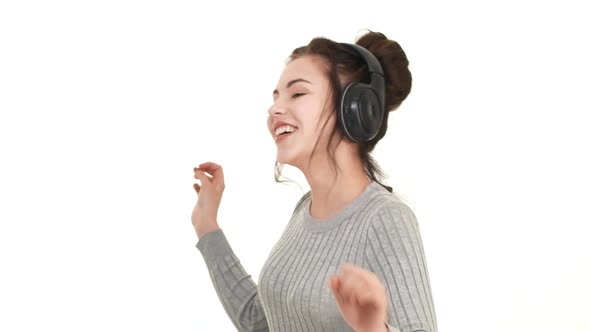 Young Beautiful Caucasian Teenager Girl Listening Music with Black Headphones with Pleasure and
