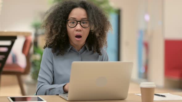 Young African Woman with Laptop Feeling Shocked