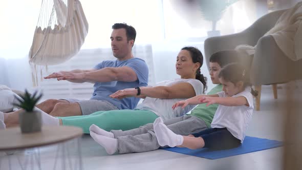 Positive Family with Kids Practicing Yoga Pose