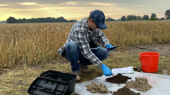 Male Specialist Measuring Soil Features By Using Soil Tester Tablet