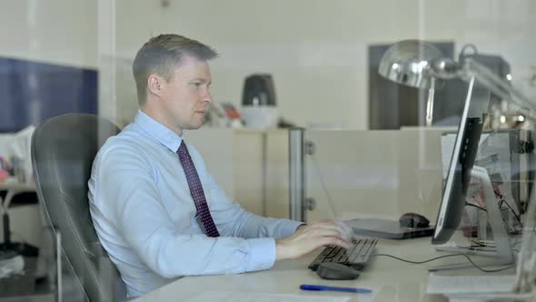 Young Handsome Businessman Working on Office Computer and Get Shocked