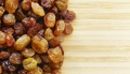 Close up picture of small raisins on a wooden background - PhotoDune Item for Sale