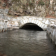Stream of Water Passes under a Small Stone Bridge - VideoHive Item for Sale
