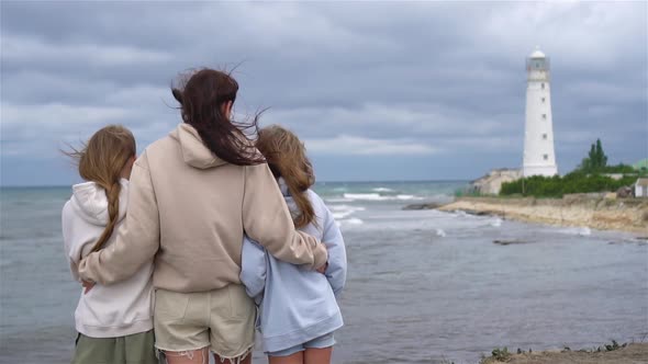 Family of Three Walk To the Lighthouse