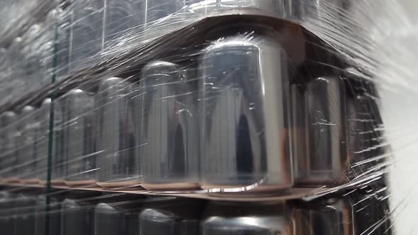 Stock of aluminum cans for cold beverages packed on pallet rack in warehouse