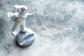 Miniature astronaut toy balancing on moon in spacesuit waving his hand. - PhotoDune Item for Sale