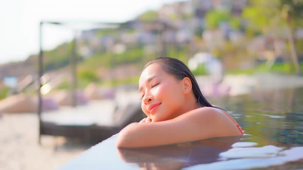 Young asian woman enjoy around outdoor swimming pool for leisure