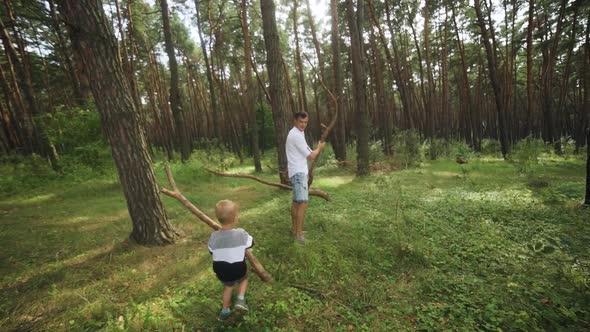 Father and son are cleaning in the forest.