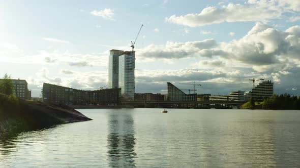 Aerial view low above the sea, towards a high rise building, under construction, during golden hour,