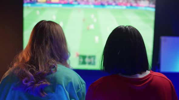 Handheld Female Gamers Plays a Football Video Game on a Console the Confrontation of Two Players